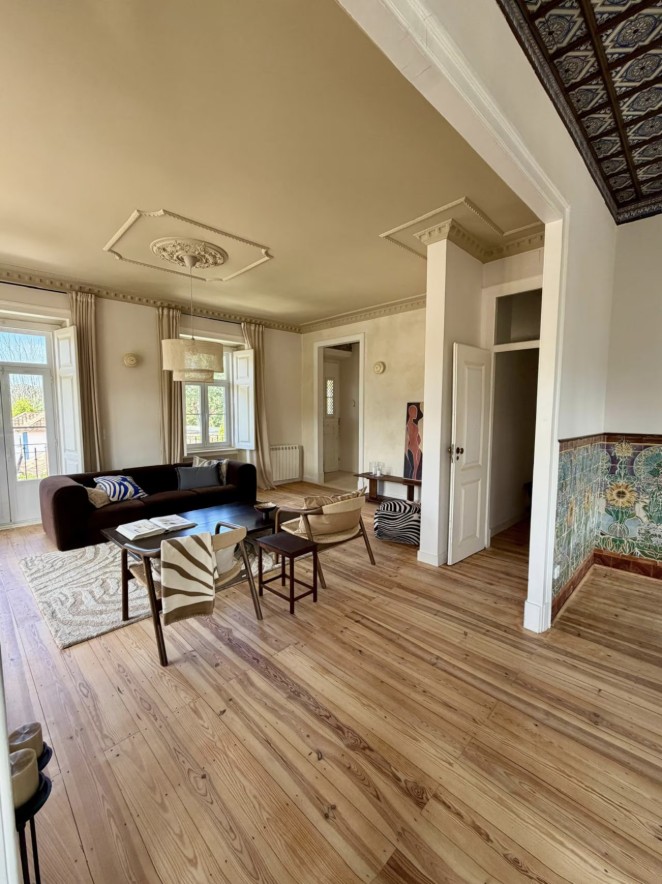 Living room with original azulejo tile, pine floors and tall windows