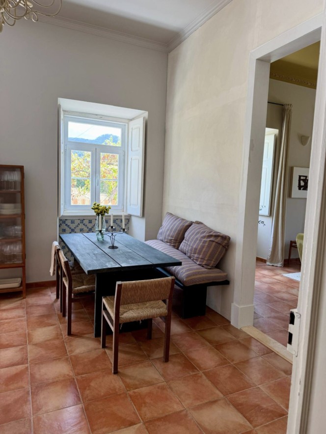 Dining nook with a bench, tiled window seat and terracotta floors