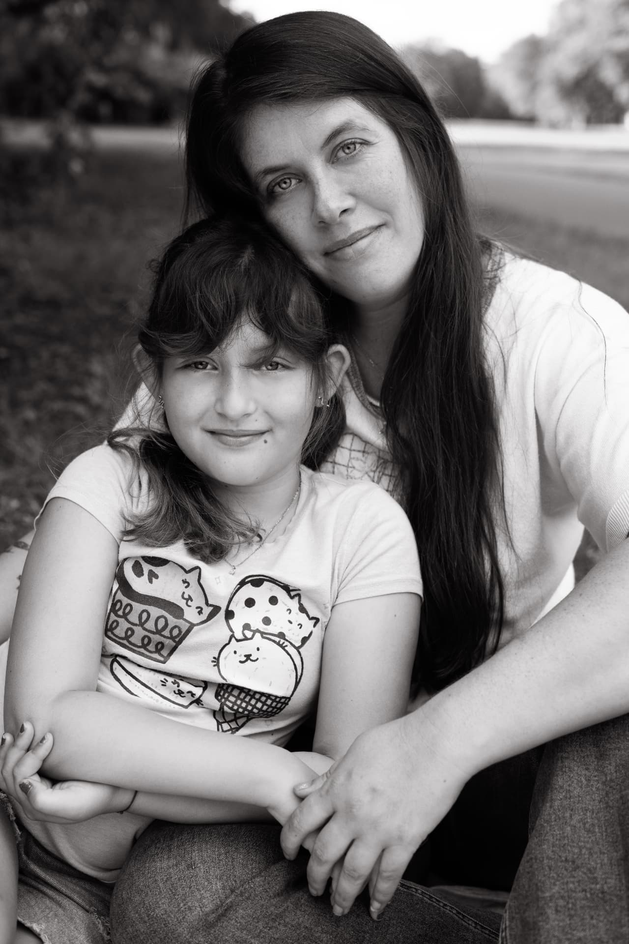 Heather and her daughter sitting together outdoors