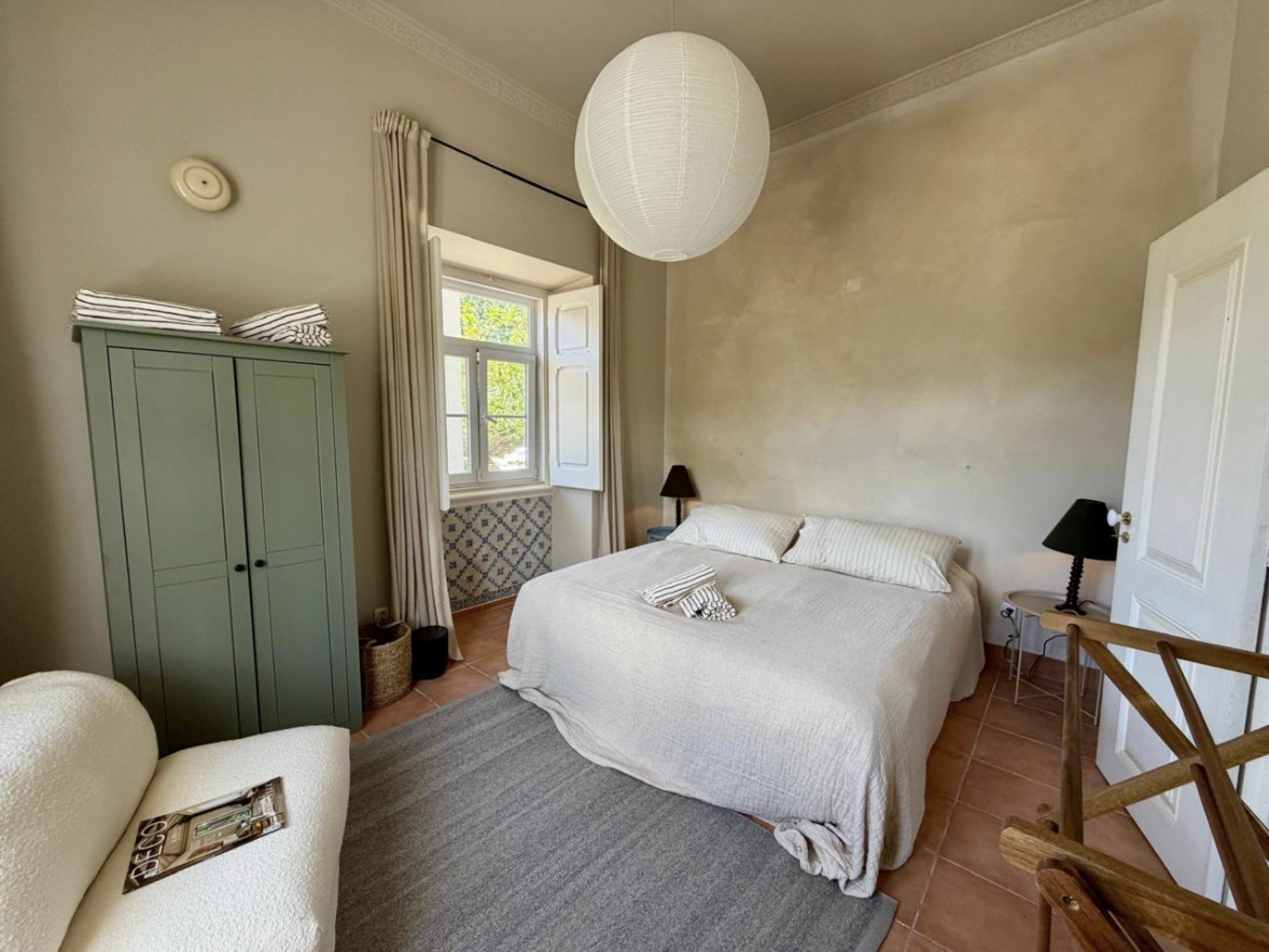 Bedroom with a green wardrobe and tiled window surround