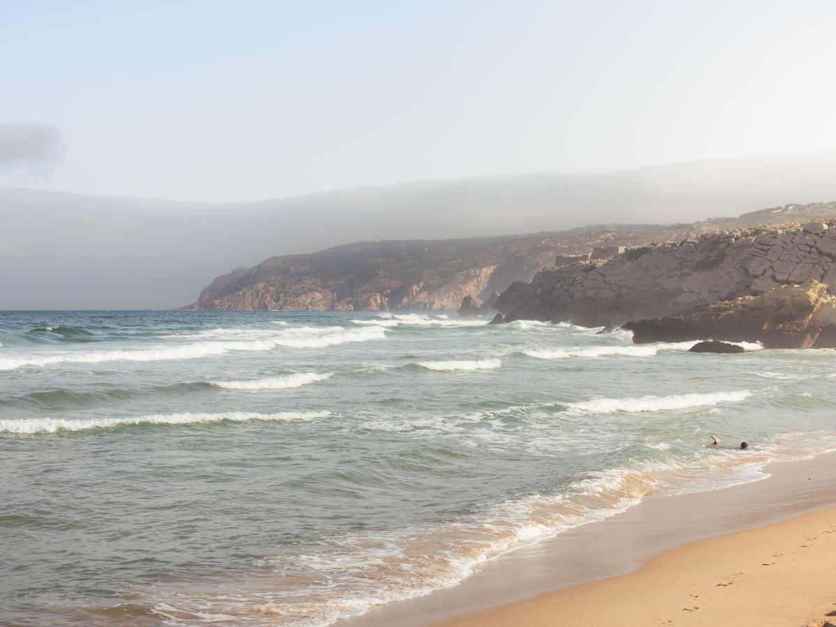 Waves rolling into Praia Grande beach on the Sintra coast in Portugal